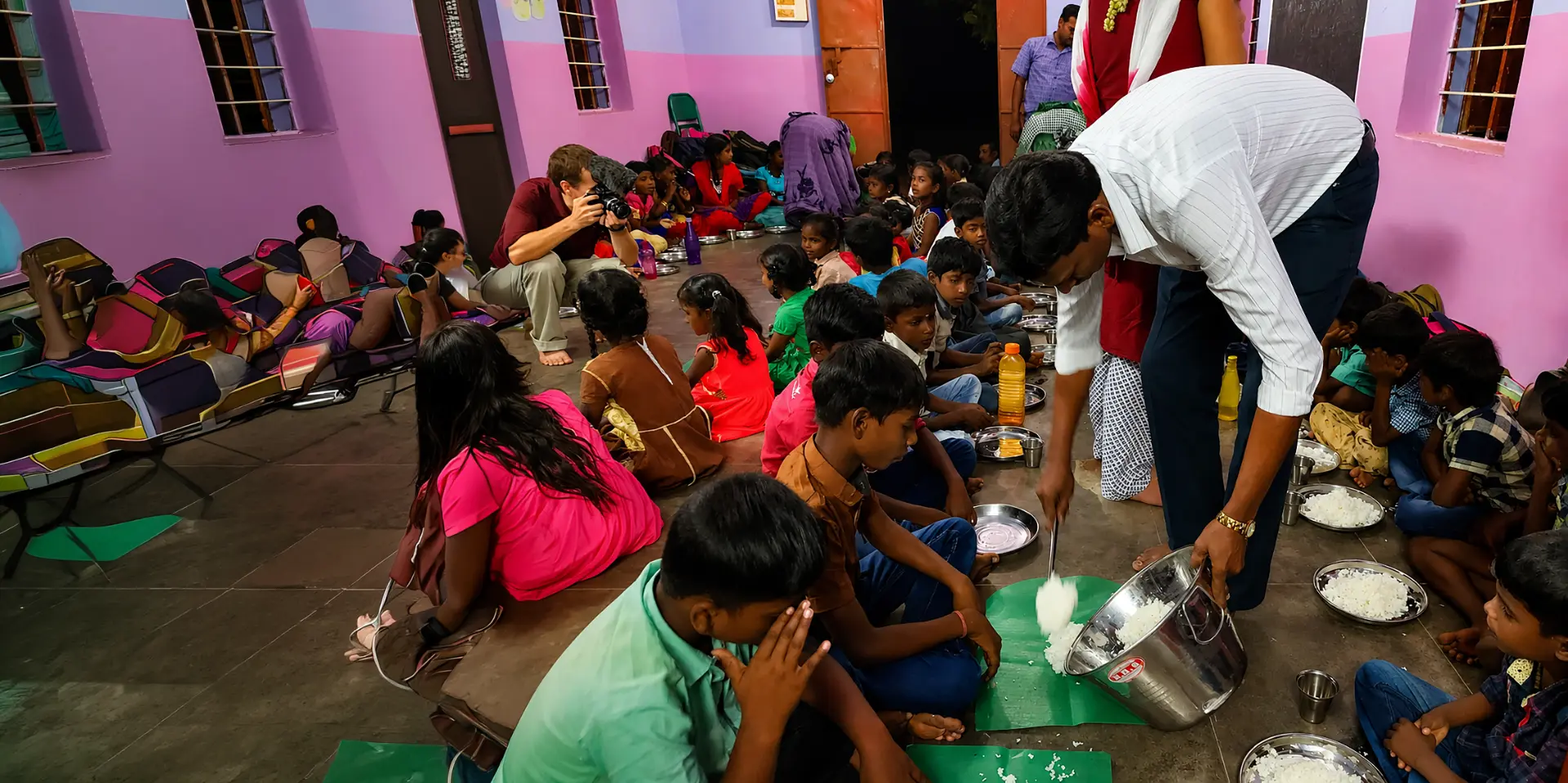Children being served rice at an evening school meal