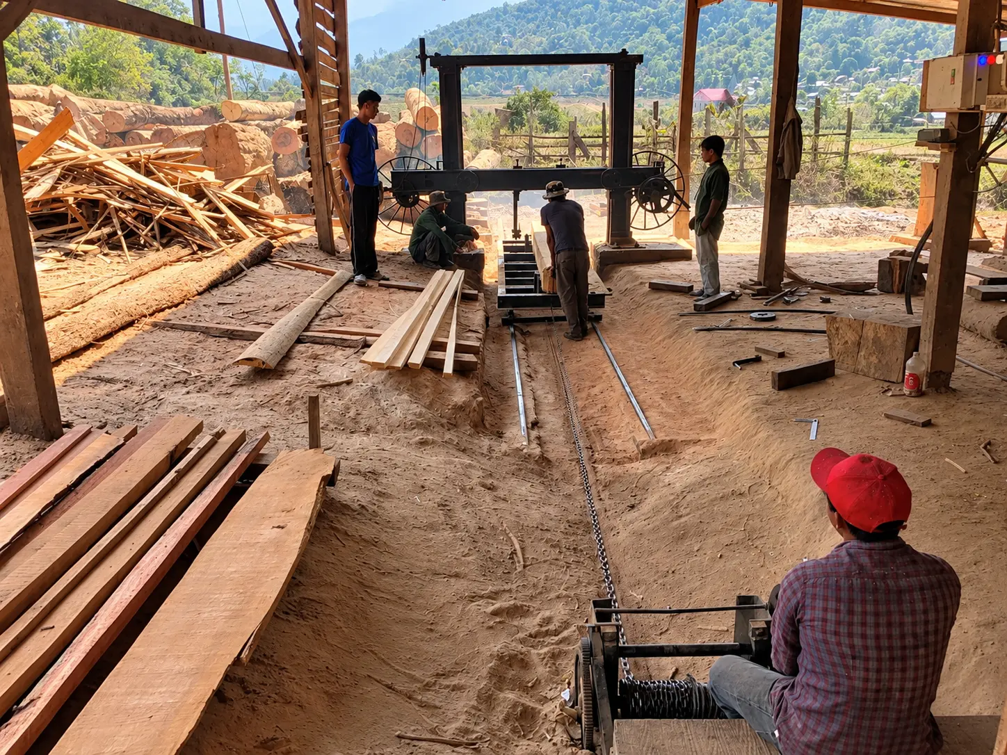Workers cutting lumber at a sawmill for a new school building