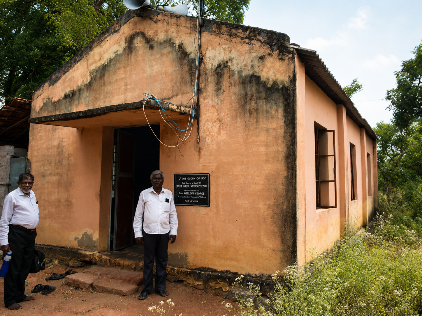 Two local church leaders standing outside a village church