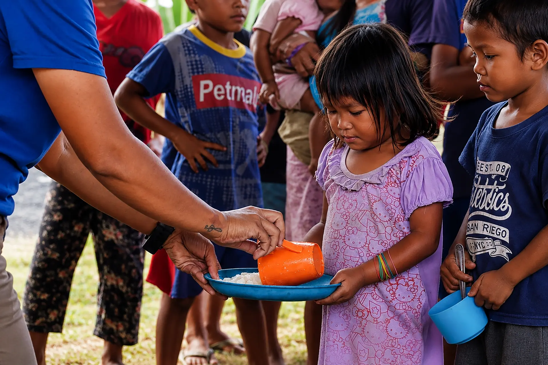Volunteers serving food to children in Asia